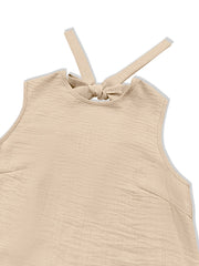 Backless mini dress in beige with tie-back detail and ruffled hem.