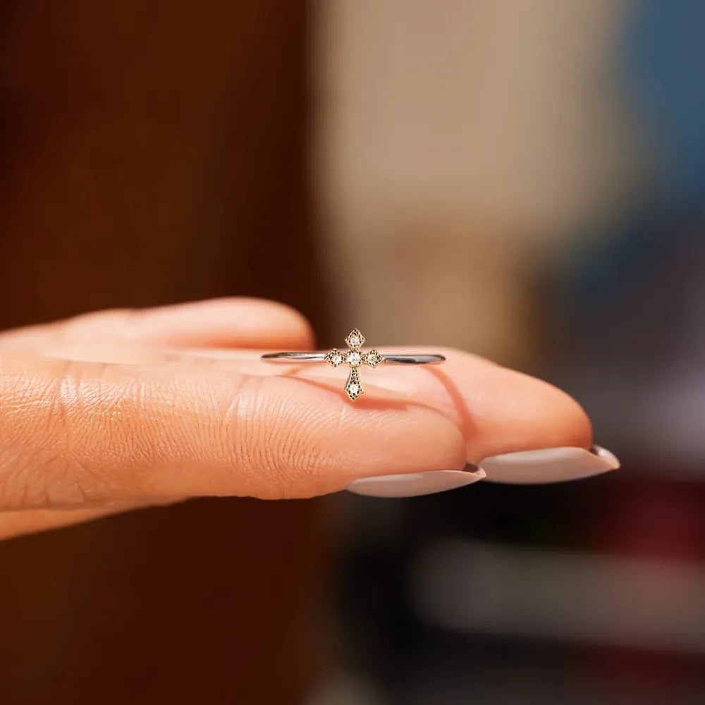 Delicate diamond cross ring in silver with small sparkling stones.