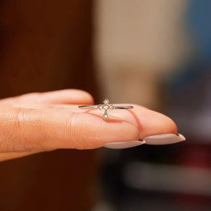 Delicate diamond cross ring in silver with small sparkling stones.