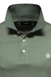 Moss green cotton polo shirt with embroidered crest detail and button placket.