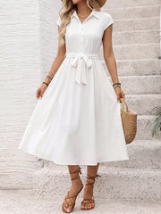 White midi dress with cap sleeves, button front, tie waist, and pleated bodice.