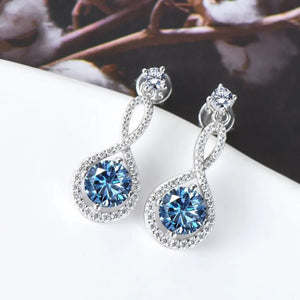Infinity drop earrings with royal blue aquamarine and diamond accents.