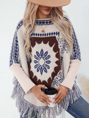 Cream acrylic poncho with Aztec motif, fringe detail, and long sleeves.