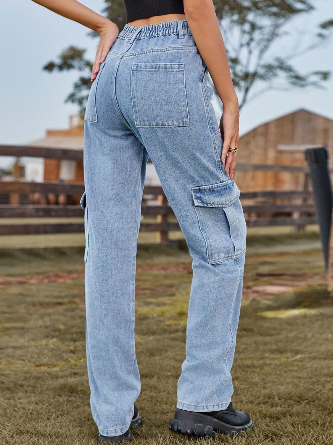 Light wash denim straight leg cargo pants with elastic waistband and multiple pockets.