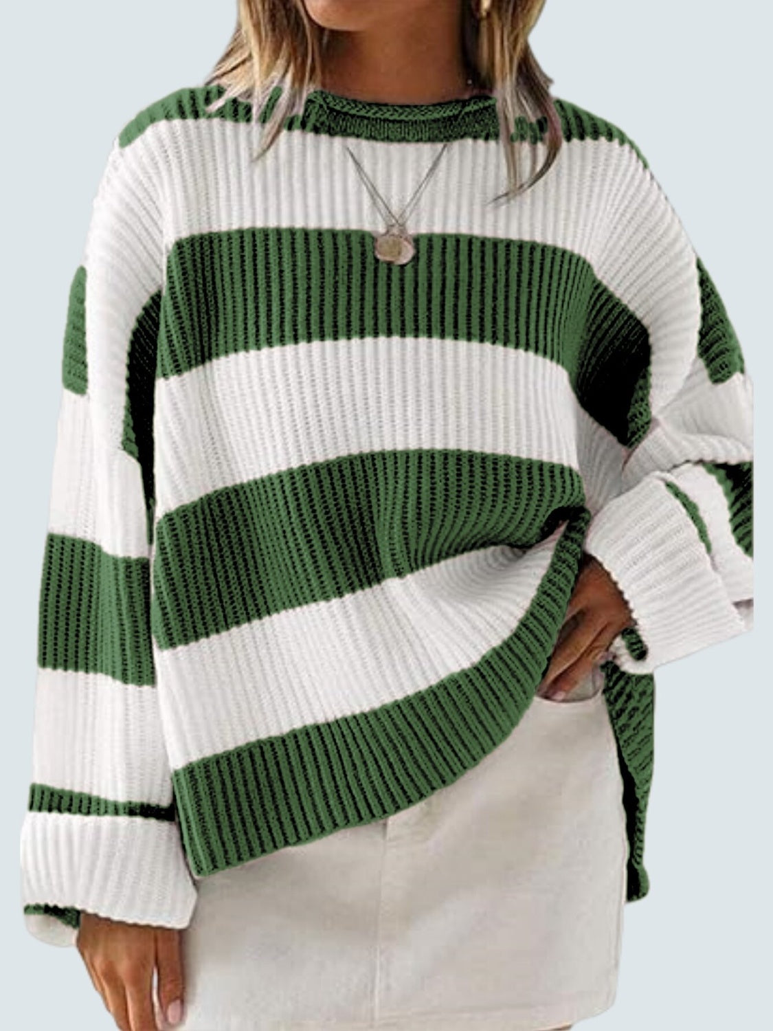 Striped oversized knit sweater in dark green and white with crew neck and long sleeves.