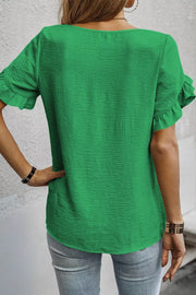 Green polyester blouse with short ruffled sleeves and textured fabric.