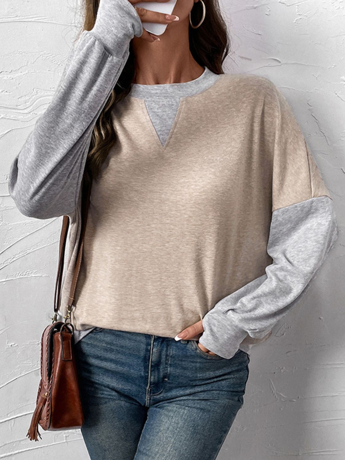 Layered V-neck sweatshirt in tan and gray colorblock with long sleeves.