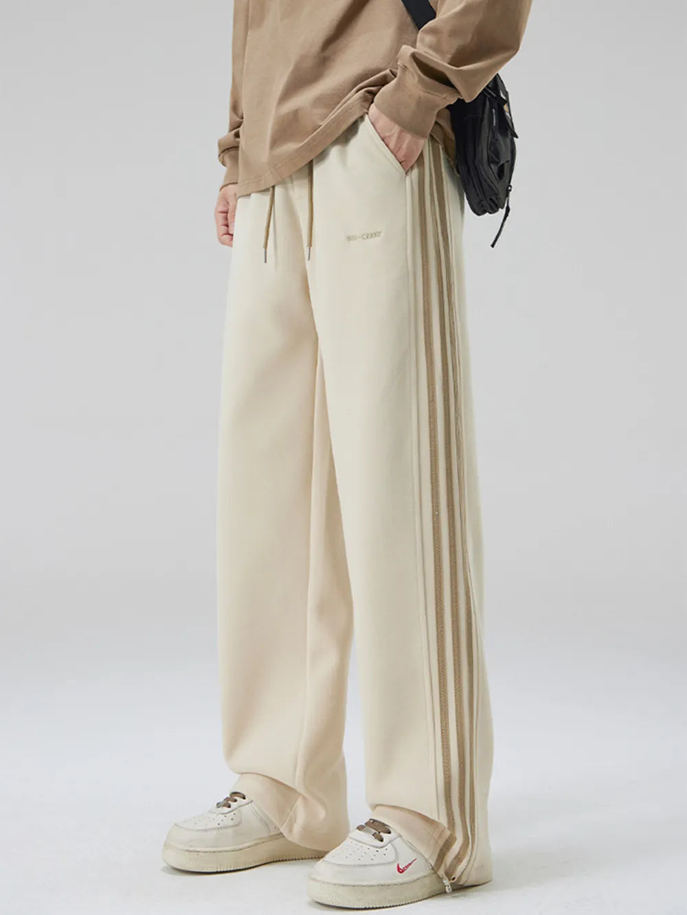 Khaki sweatpants with side stripes and drawstring waist.