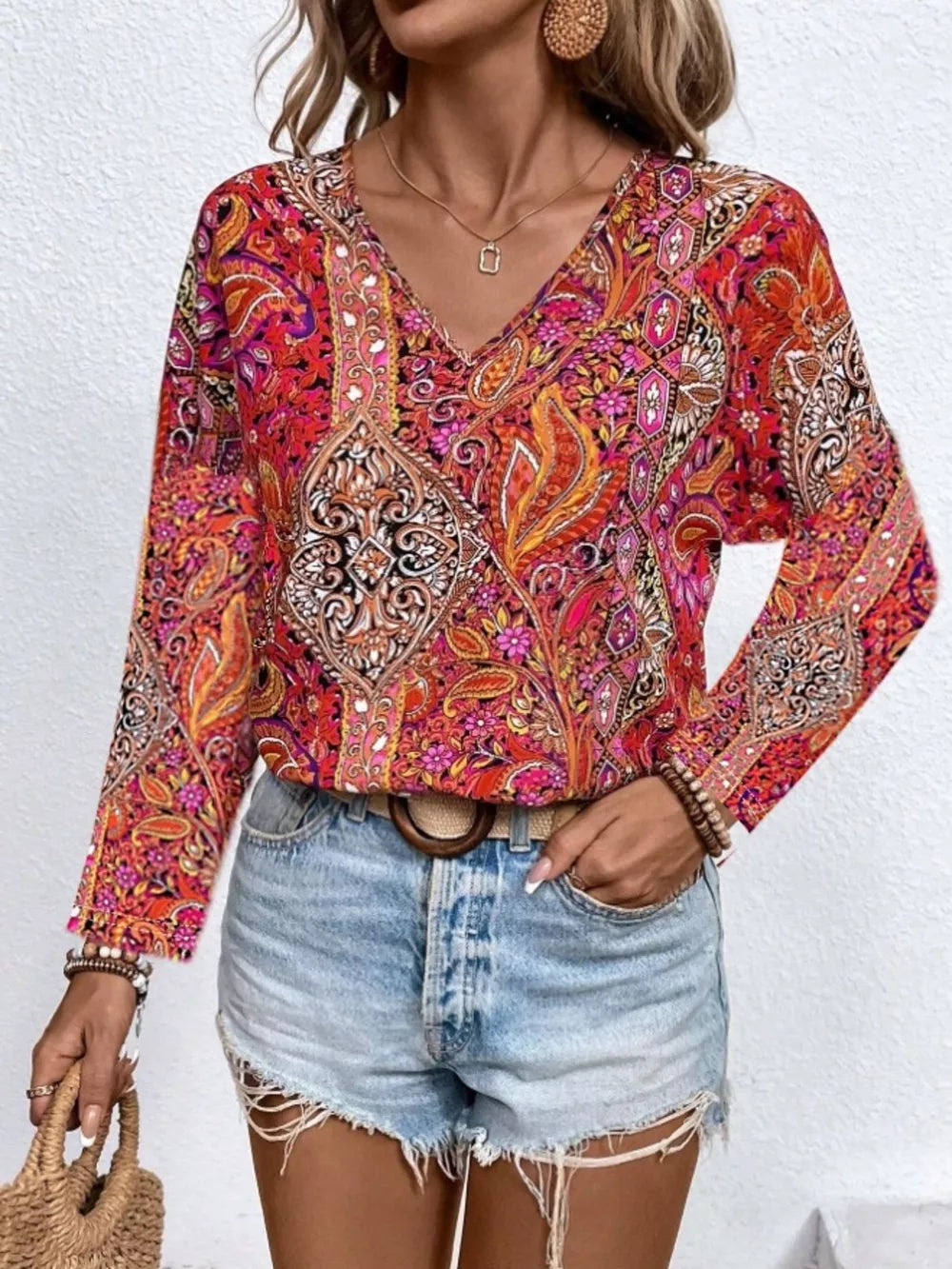 Bohemian paisley v-neck shirt in multicolor with long sleeves, styled with denim shorts.