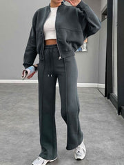 Dark blue bomber jacket and wide-leg tracksuit with drawstring pants and white crop top.
