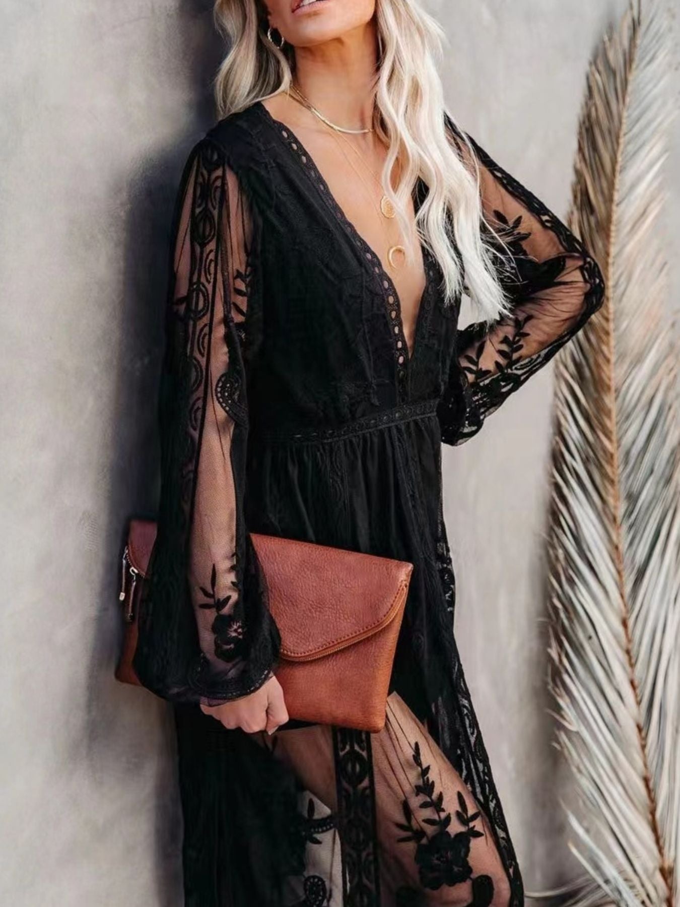 Black floral lace maxi dress with plunging neckline, long bell sleeves, and a thigh-high slit.
