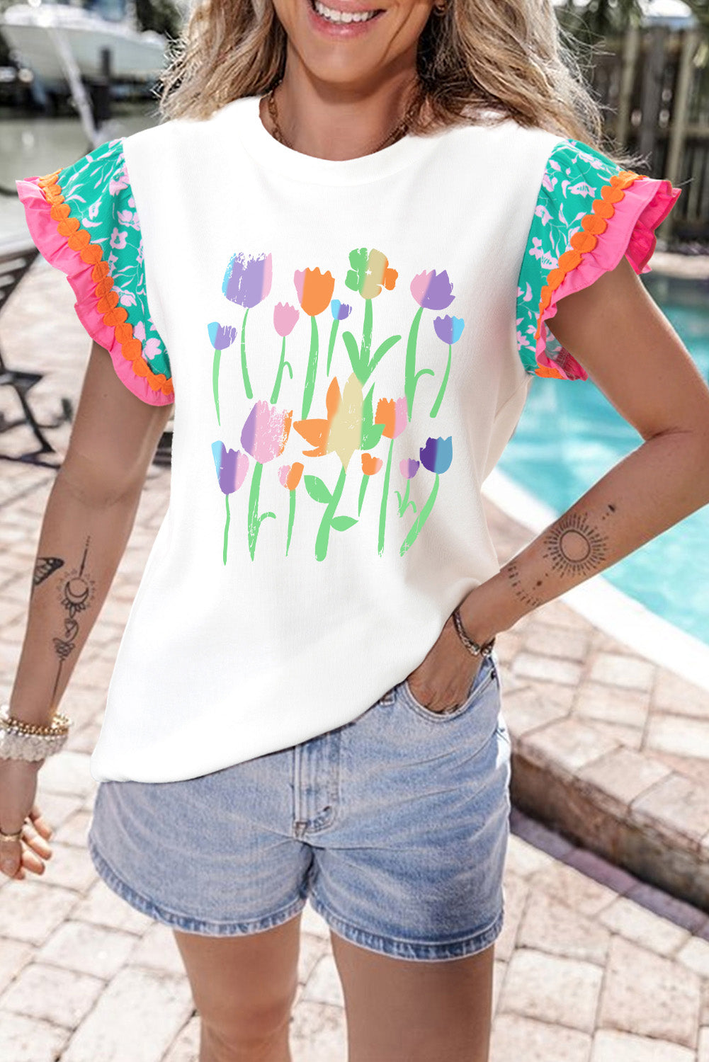 White floral print t-shirt with ruffle sleeves and colorful tulip graphic.