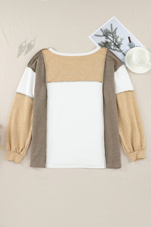 Colorblock knit top in tan, white, and brown with seam details and long sleeves.
