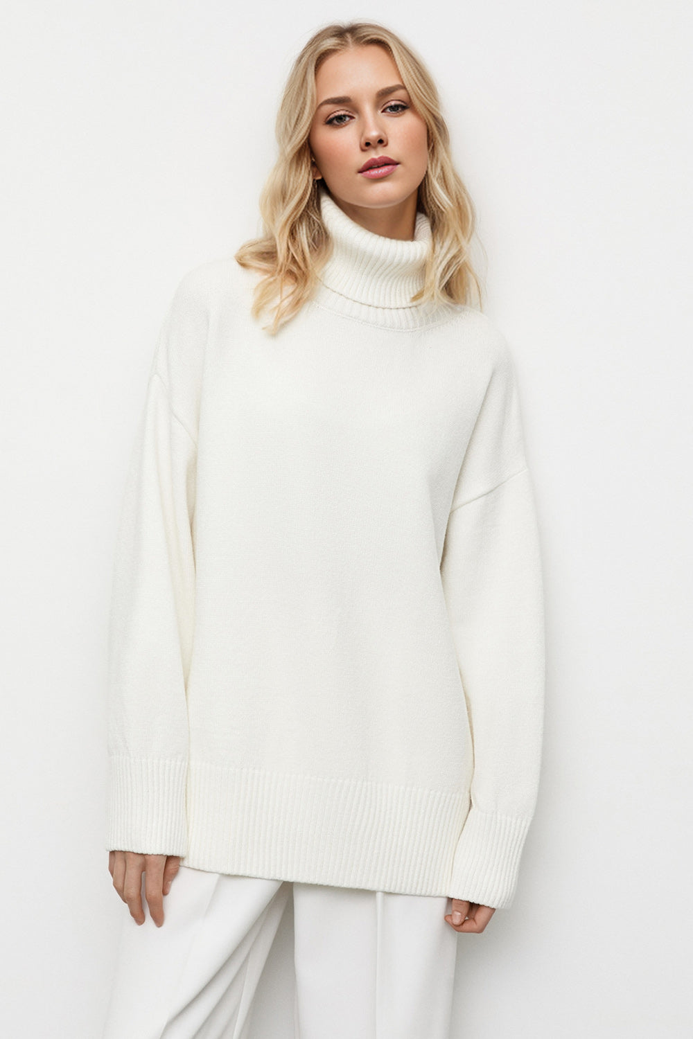 Oversized white turtleneck sweater with ribbed cuffs and hem, relaxed fit.