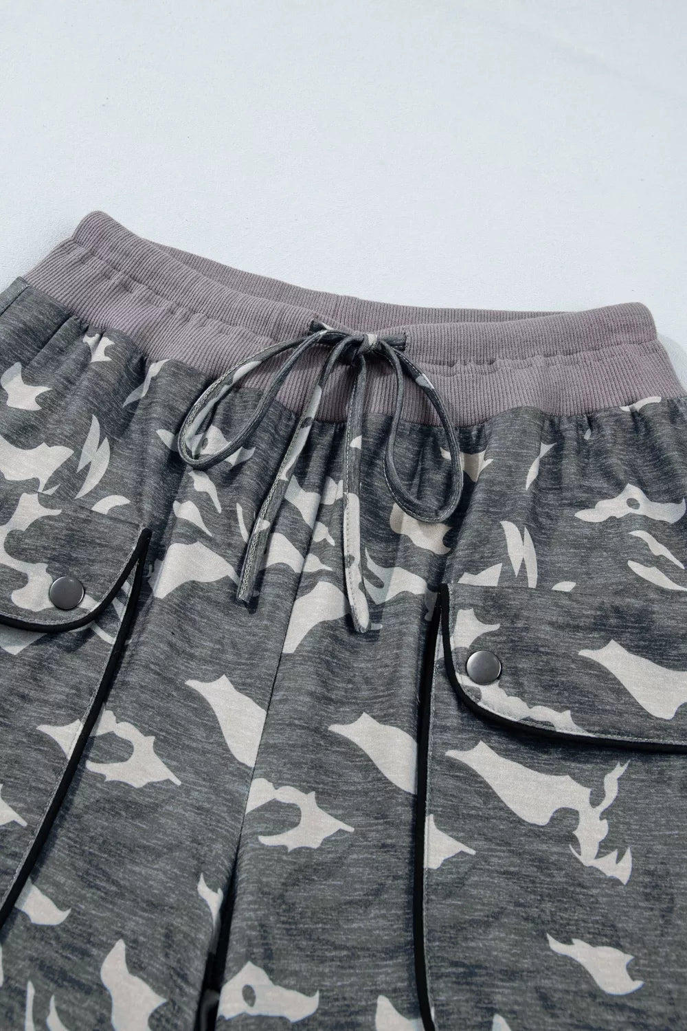Camouflage barrel pants with cargo pockets, drawstring waist, and ribbed waistband.