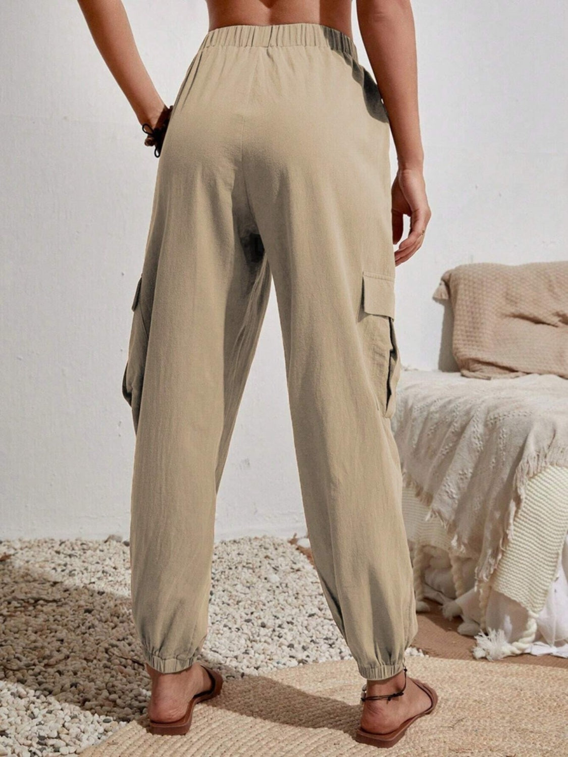 Khaki cargo lounge trousers with elastic waist and cuffs, featuring side cargo pockets.
