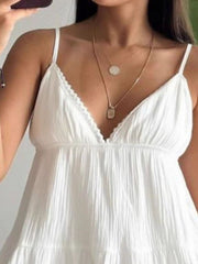 White cotton tiered mini dress with lace trim neckline and spaghetti straps.