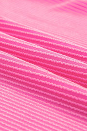 Vibrant ribbed V-neck t-shirt in bright pink with textured horizontal stripes.