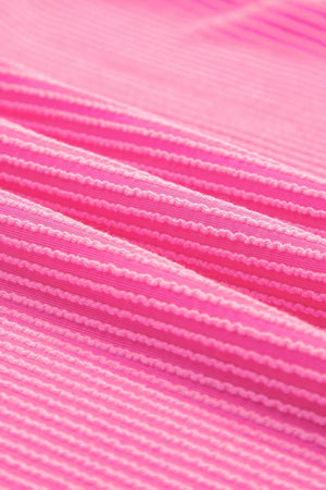 Vibrant ribbed V-neck t-shirt in bright pink with textured horizontal stripes.