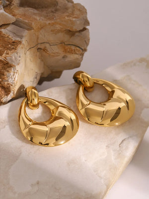 Gold sculpted statement earrings with a polished finish and textured detail.