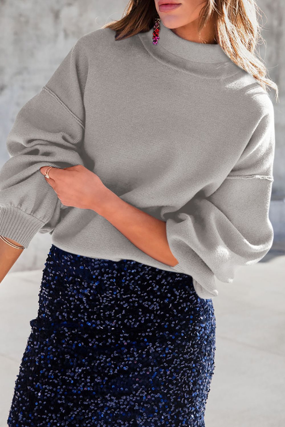 Gray mock neck knit sweater with balloon sleeves and ribbed cuffs.