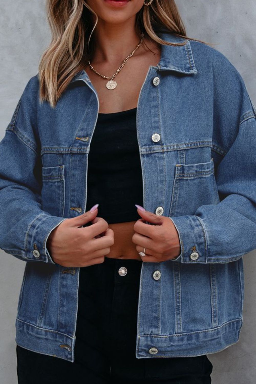 Oversized washed black denim trucker jacket with button front and chest pockets.