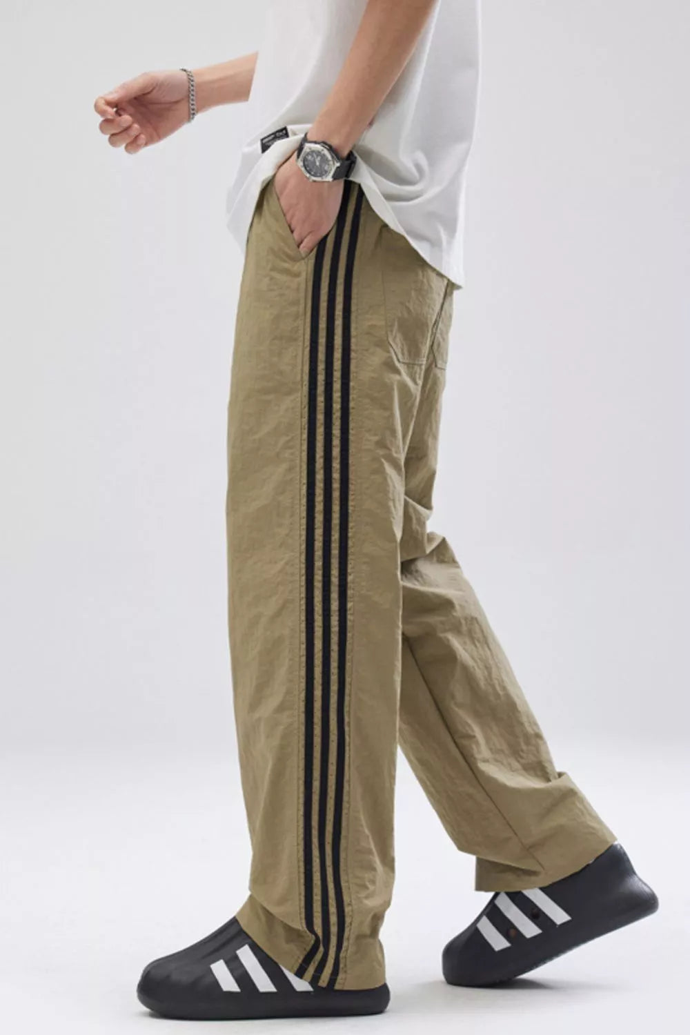 Khaki relaxed fit wide-leg sweatpants with black side stripes.