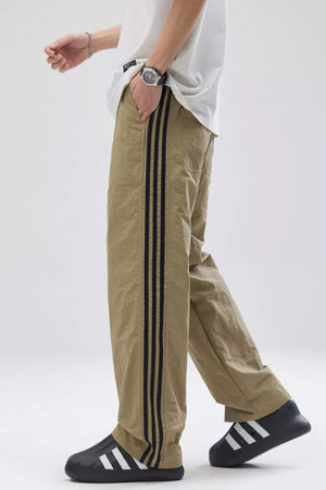 Khaki relaxed fit wide-leg sweatpants with black side stripes.