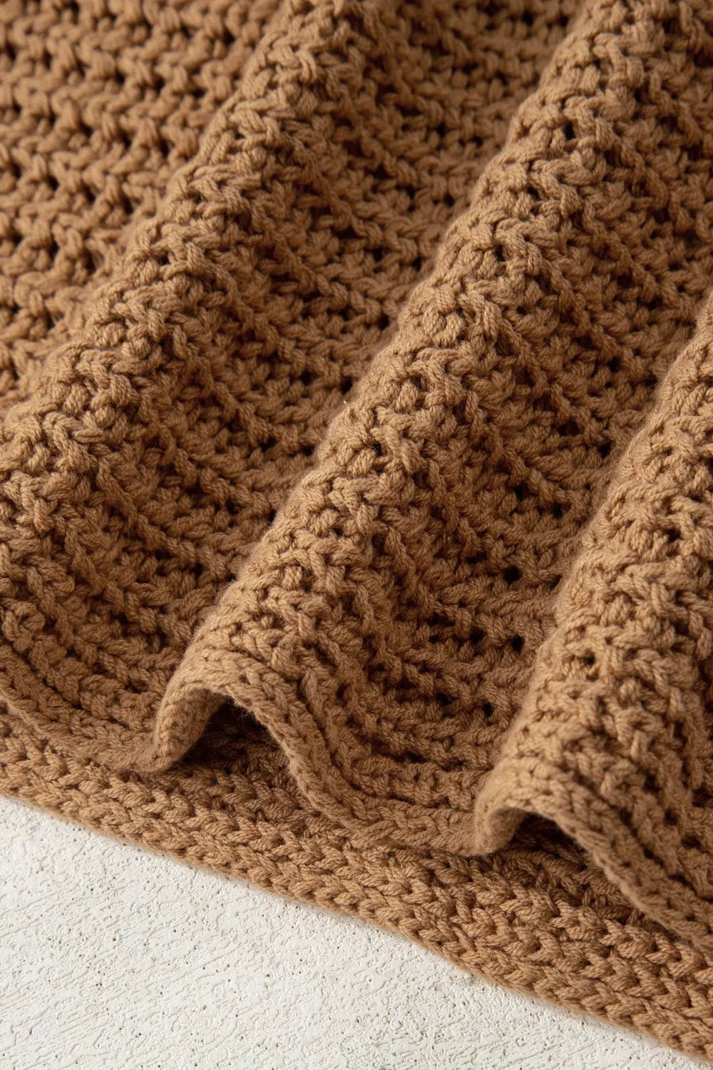 Textured brown knit pullover sweater with wide bell sleeves and a chunky knit pattern.