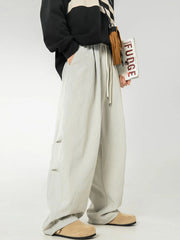 Light gray balloon-fit drawstring trousers with pleated front and side detail.