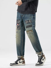 Men's distressed blue cotton jeans with artisan patchwork and rolled cuffs.