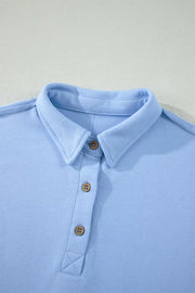 Light blue sleeveless polo shirt with wooden buttons and collar detail
