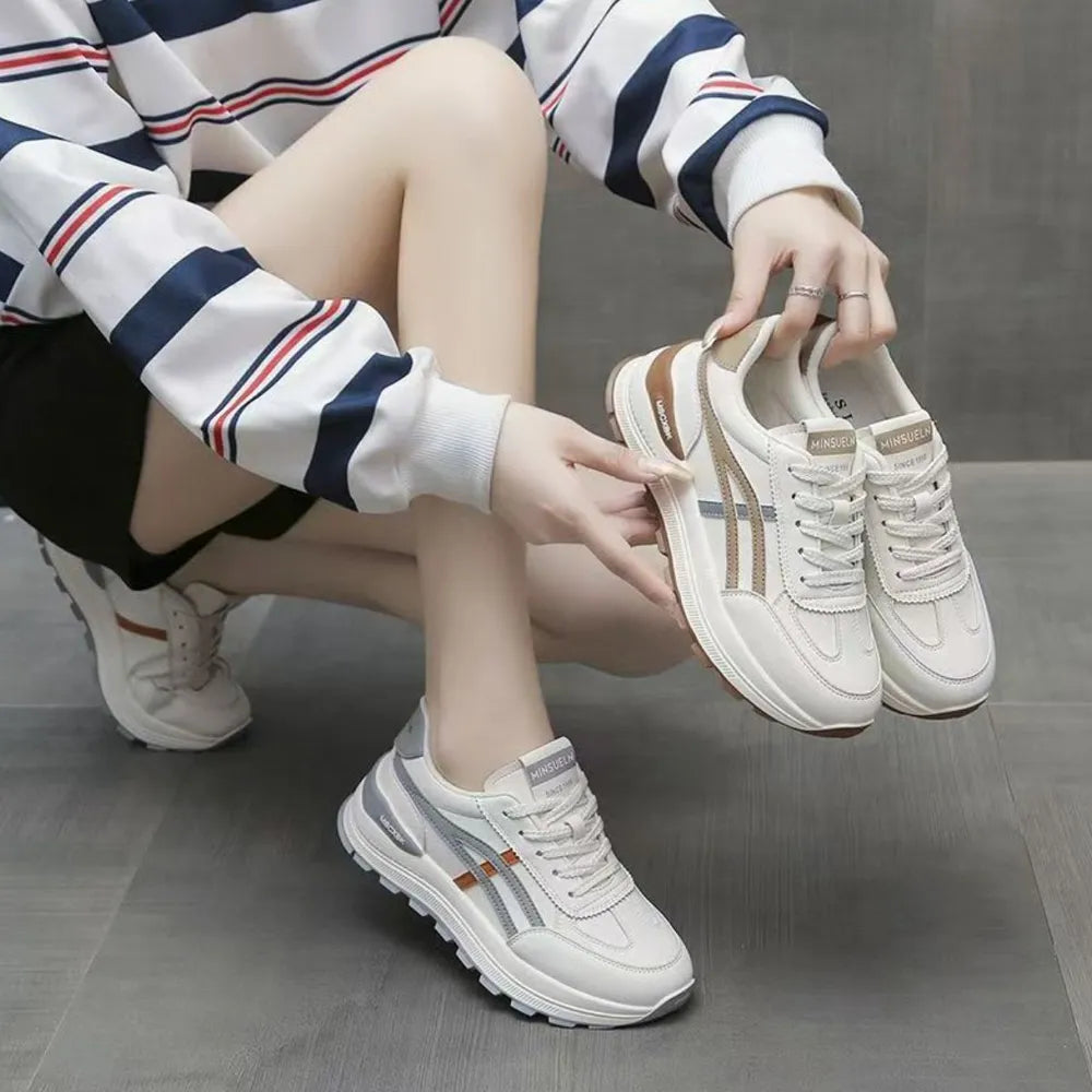 Retro platform sneakers in white with gray and orange contrast stripes and laces.