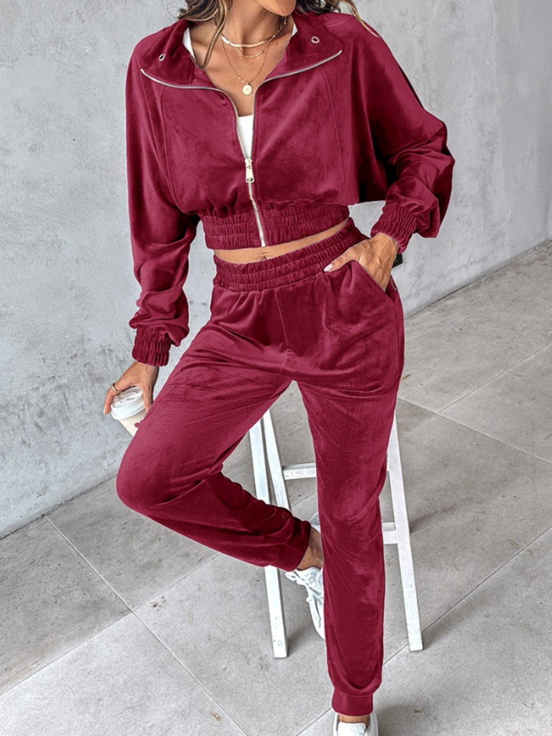 Velvet crop tracksuit in burgundy with zipper detail and elastic waistband.