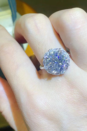 Silver moissanite statement ring with a large round center stone and halo detail.