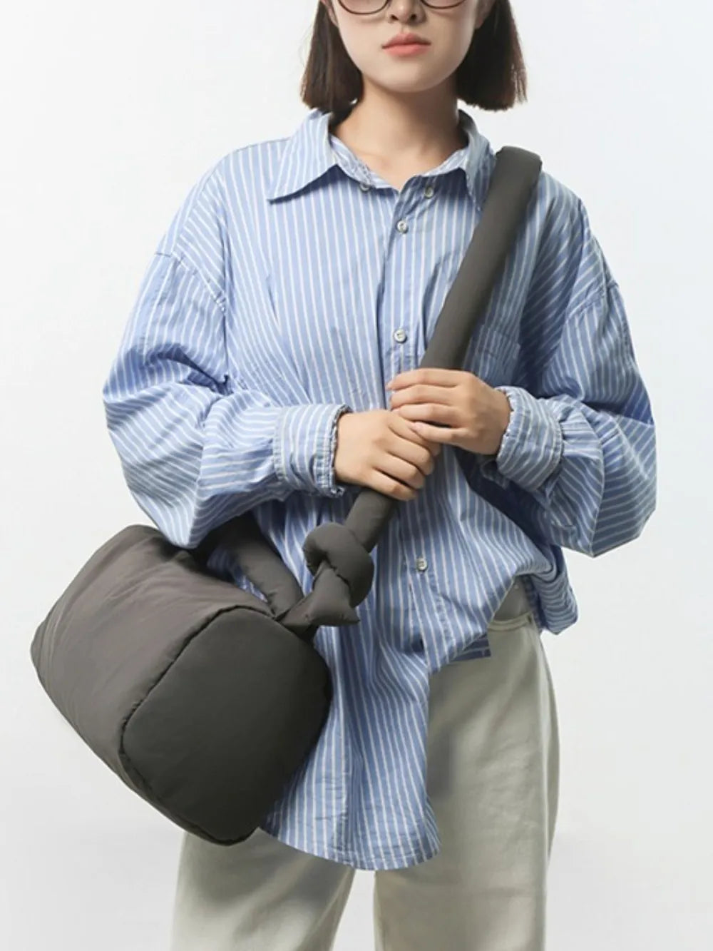 Dark gray padded knot shoulder bag with a soft, puffy texture.