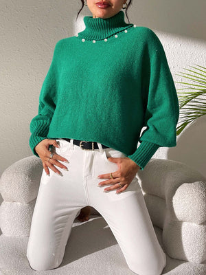 Green knit sweater with pearl details on the neckline and dolman sleeves.