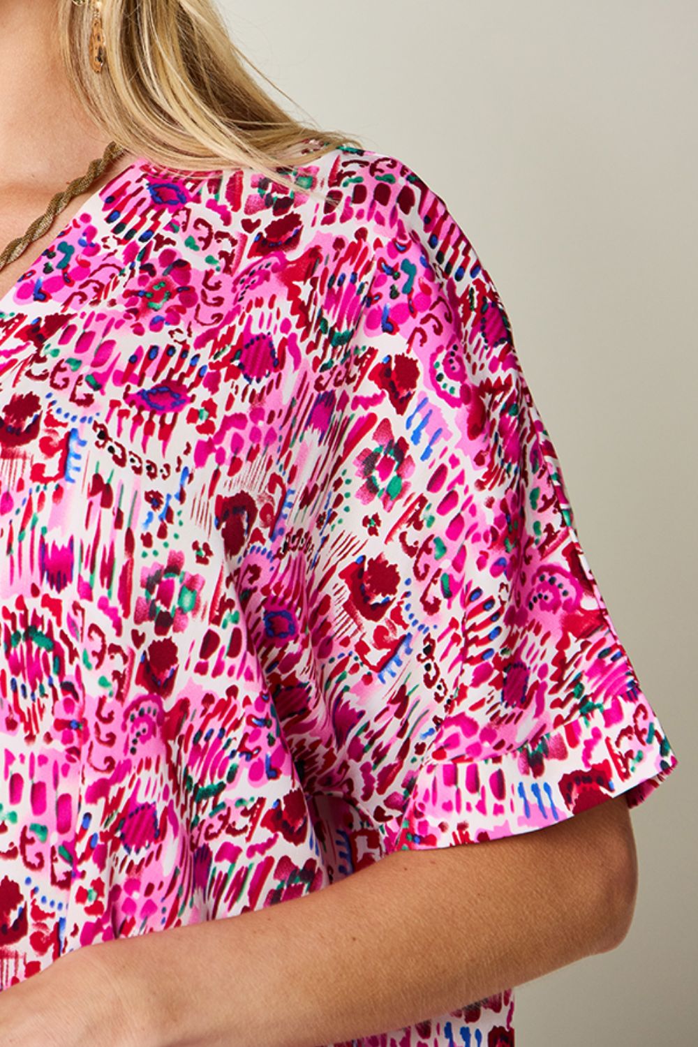 Floral ikat relaxed v-neck top in pink with short sleeves and a vibrant abstract print.