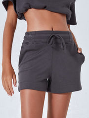 Dark gray drawstring pocket shorts with elastic waistband and cuffed hem.