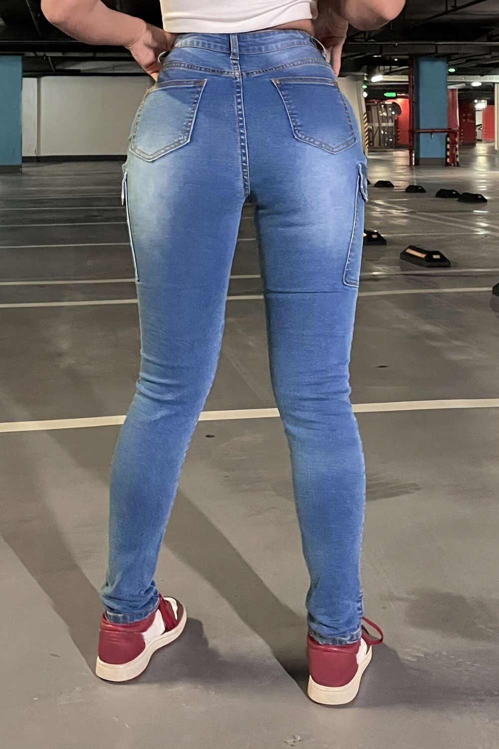 Medium wash skinny cargo jeans with a cotton blend, shown from the back.