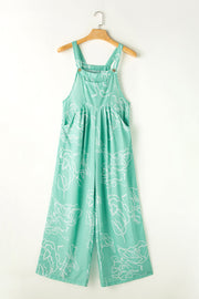 Turquoise botanical print wide-leg jumpsuit with pockets and adjustable straps.