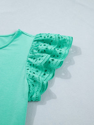 Green eyelet lace ruffled cap sleeve top with scalloped hem detail.