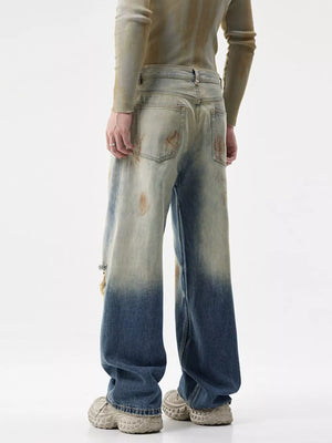 Men's distressed wide-leg jeans with ombre wash and ripped details.