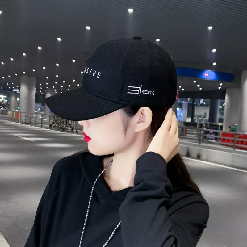 Black cotton baseball cap with white embroidery detail and text.