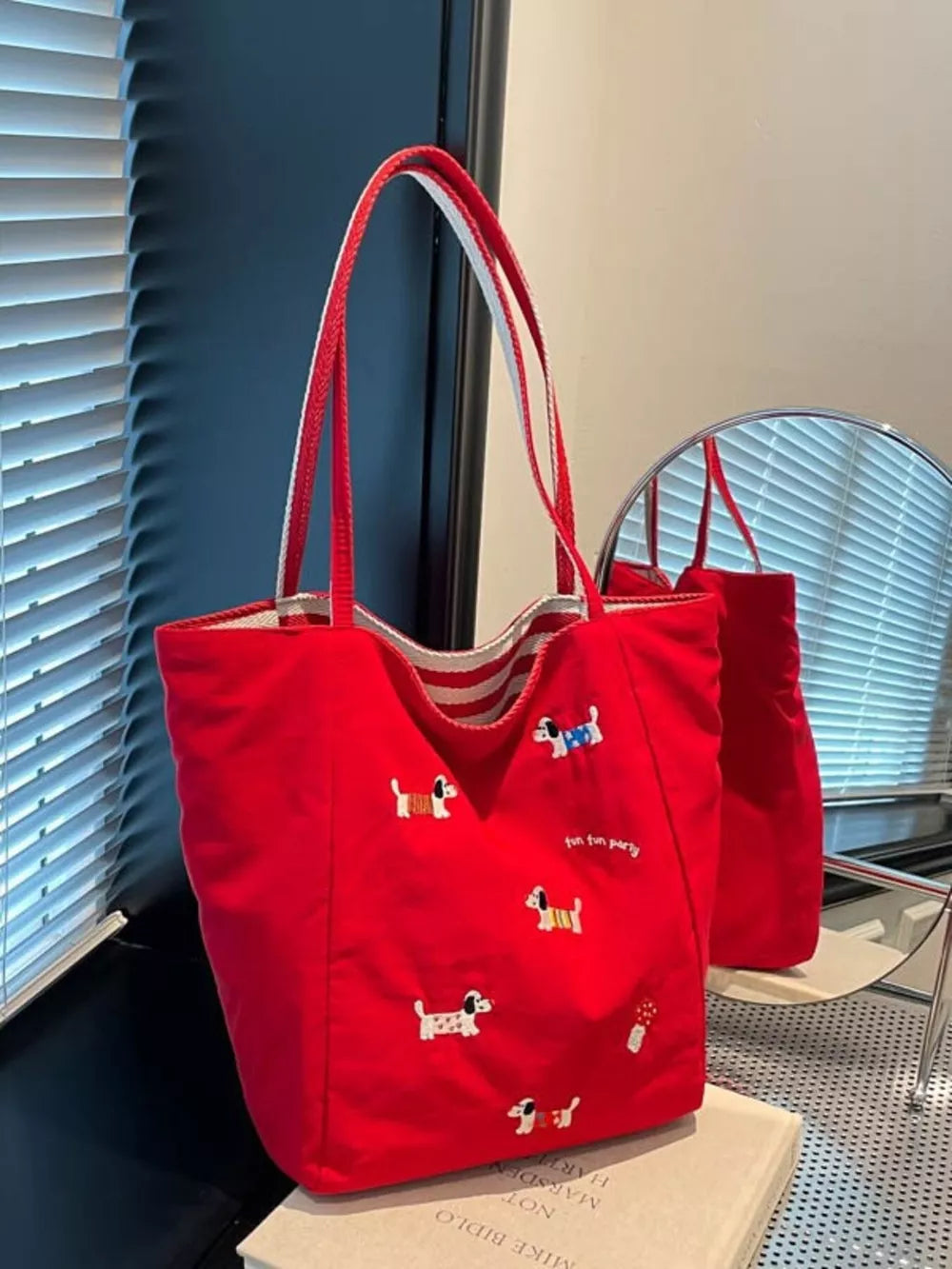 Red shoulder bag with embroidered dachshunds and striped handles