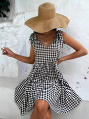 Black and white gingham tie-shoulder mini dress with tiered skirt.
