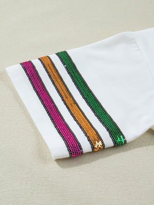 White cotton t-shirt with sequin stripes in pink, gold, and green on the sleeve.