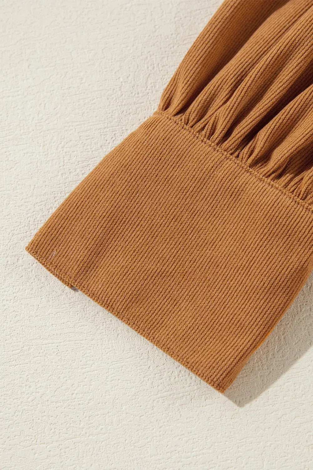 Caramel corduroy mini dress with puff sleeves and ruched cuff detail.