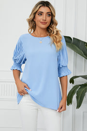 Light blue blouse with pleated sleeves and smocked cuffs