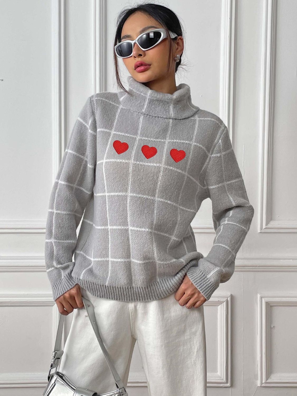 Light gray turtleneck sweater with white grid pattern and three red heart appliqués.